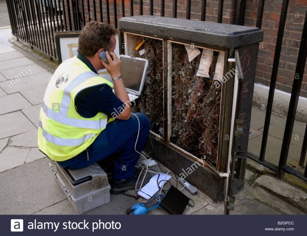 Telephone Repair Engineer At Phone Junction Box On Pavement Stock